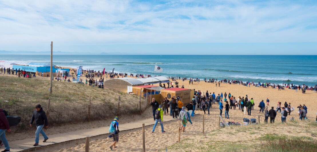 Eine Veranstaltung mit vielen Menschen an einem Strand am Meer