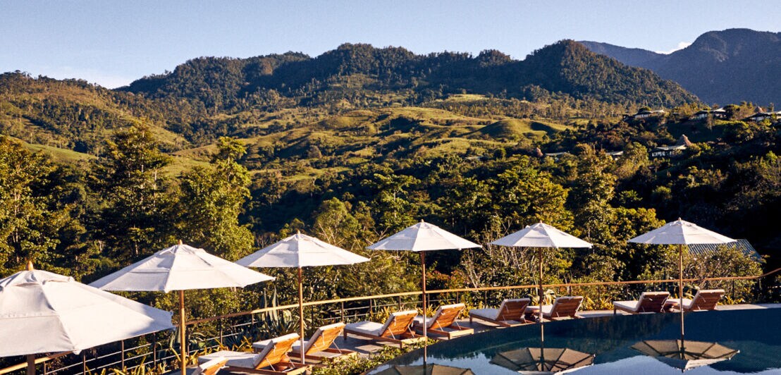 Ein Pool mit Liegen und Blick auf die Berge Costa Ricas