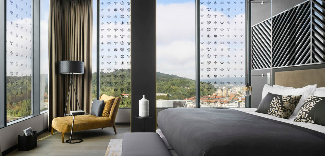 Modernes Hotelzimmer mit Blick auf die Stadt und einen Wald