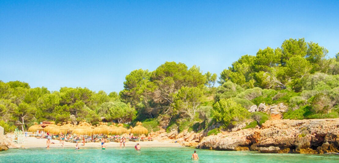 Menschen an der Bucht Cala Sa Nau auf Mallorca