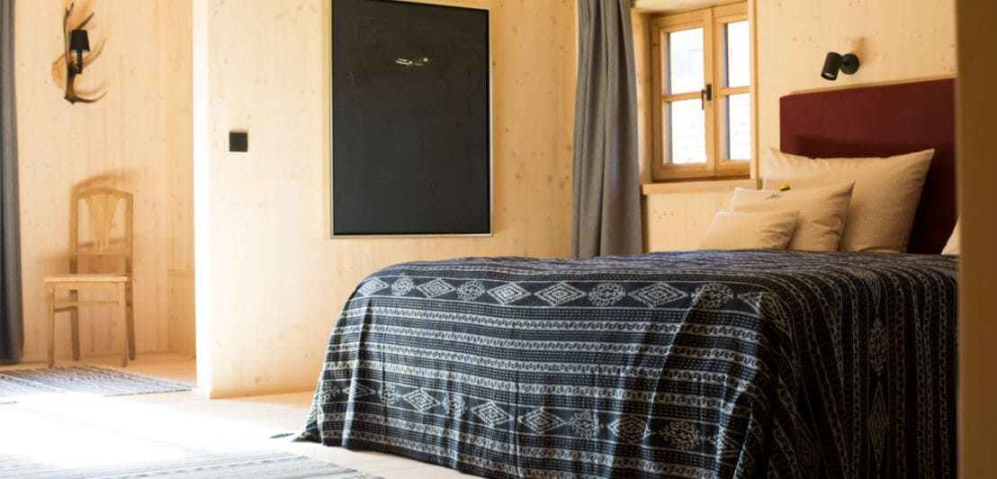 Holzverkleidetes Zimmer mit Doppelbett