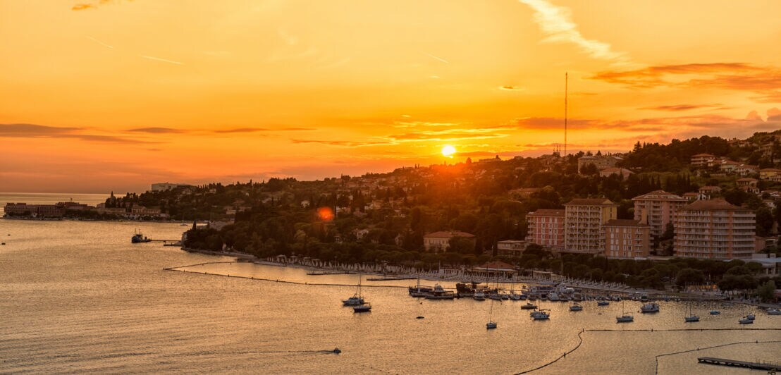 Panoramablick auf eine Hafenstadt bei Sonnenuntergang.