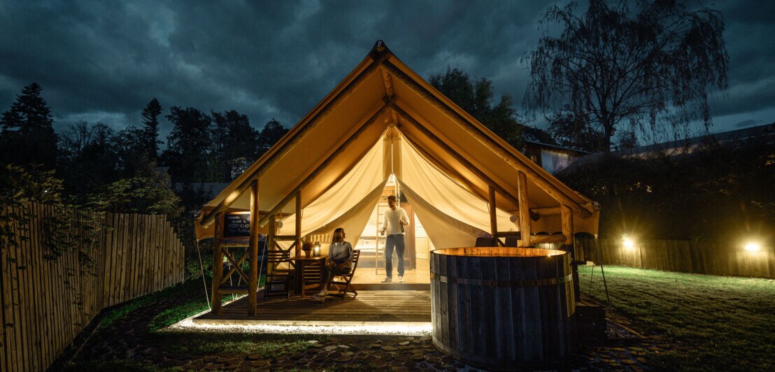 Ein stabiles, luxuriöses Zelt, das bei Nacht beleuchtet wird.
