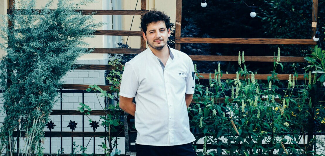 Porträt von Koch Maurizio Oster vor seinem Restaurant