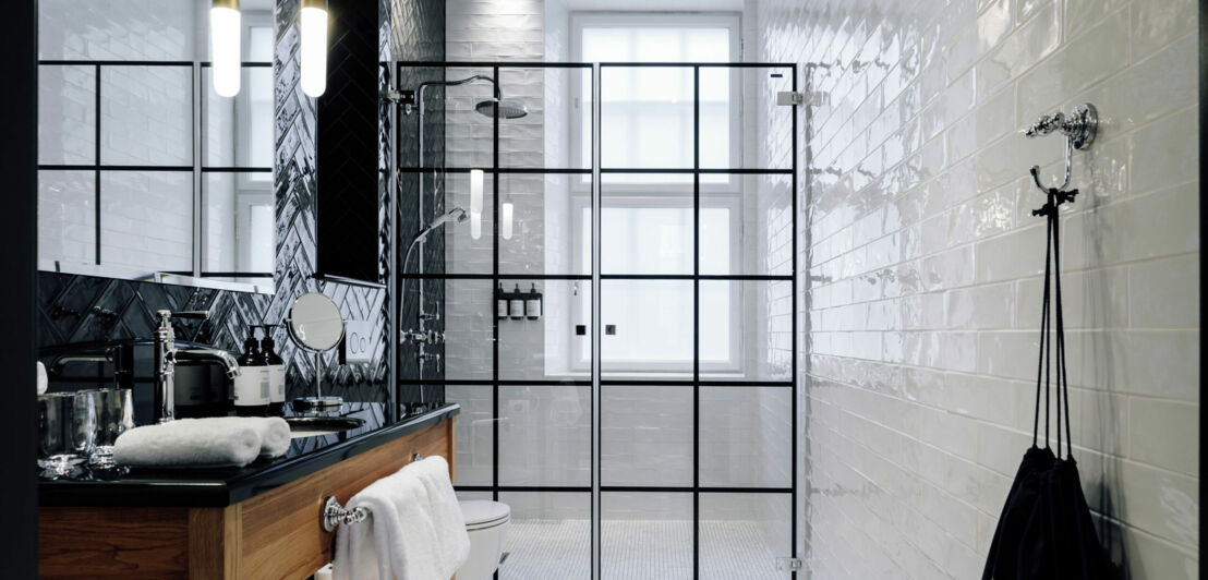 Modernes Hotel-Badezimmer mit großer Dusche in Schwarz und Weiß