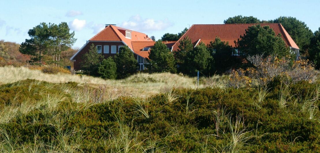 Ein großes Landhaus inmitten grasbedeckter Dünen