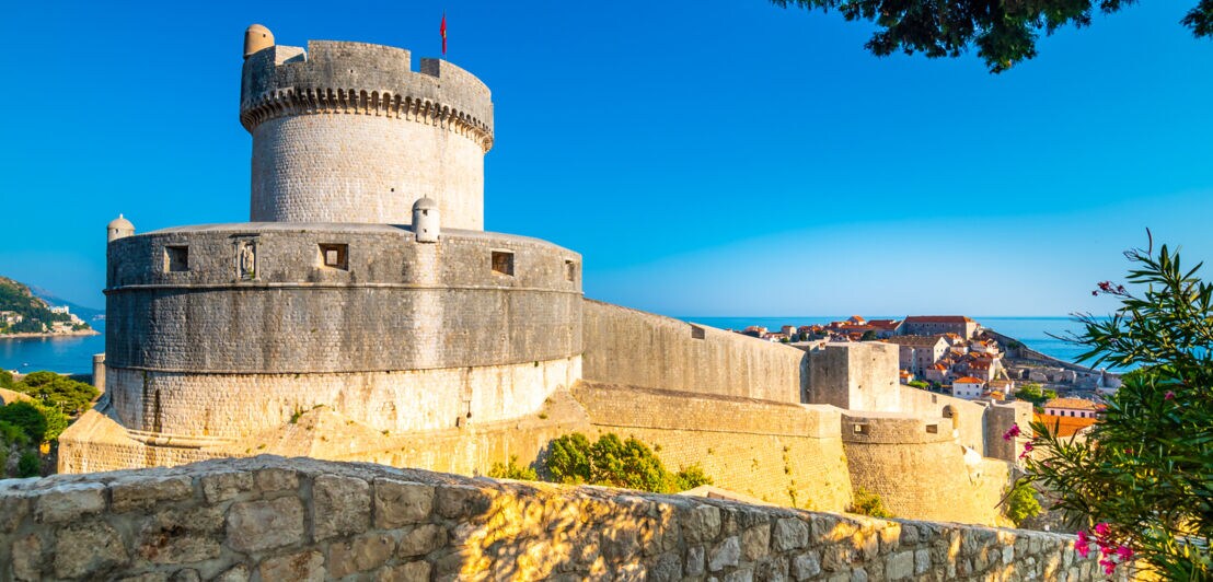 Ein runder Turm auf einer mittelalterlichen Festungsanlage einer Stadt am Meer
