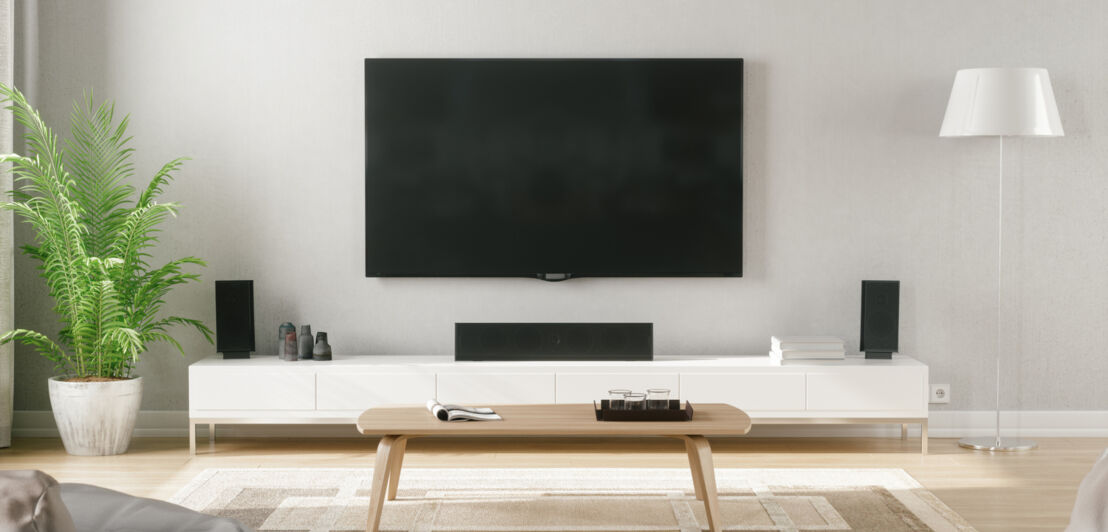 Ein stilvoll eingerichtetes Wohnzimmer mit Blick auf den Fernseher und das Soundsystem