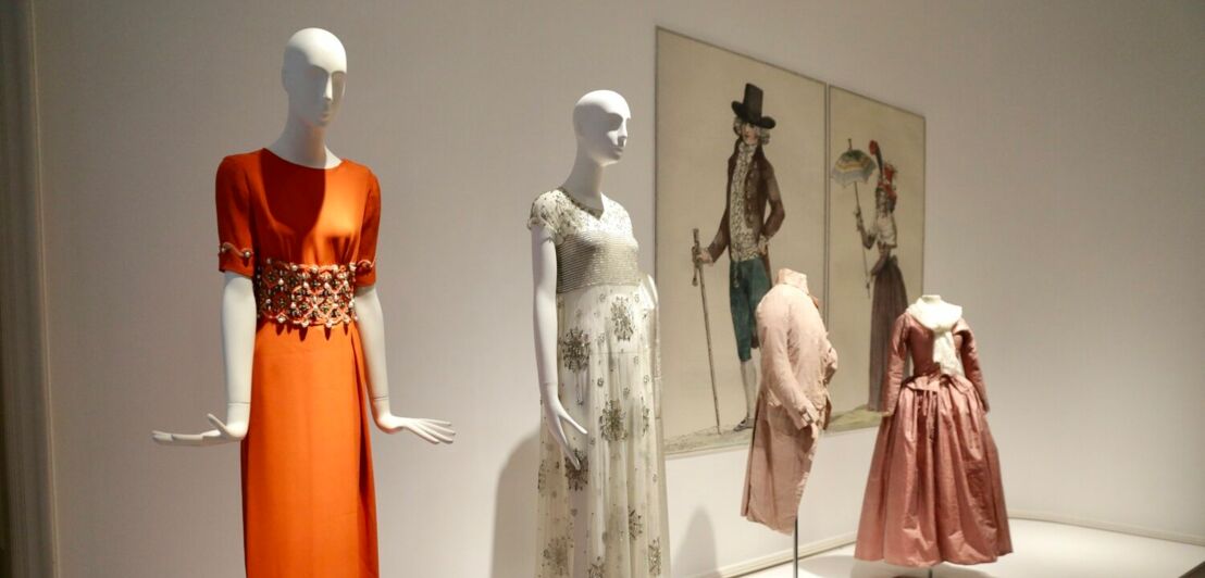 Vier Schaufensterpuppen in historischen Kleidern in einem Museum