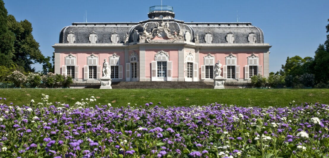 Eine Schlossanlage auf einem Grundstück mit Blumenwiese