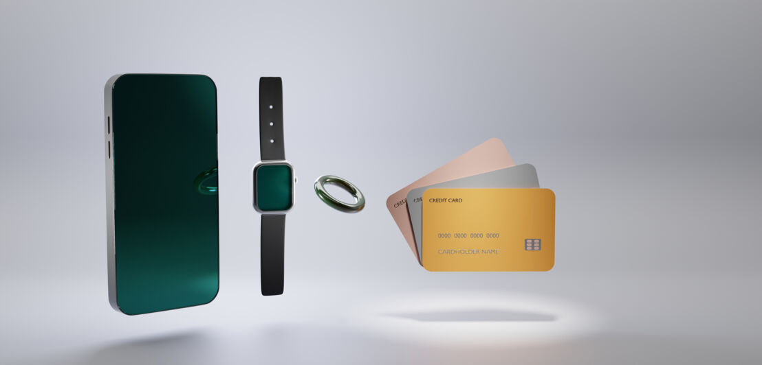 Smartphone mit leerem Bildschirm, Smartwatch, ein Ring und drei Kreditkarten isoliert auf grauem Hintergrund.
