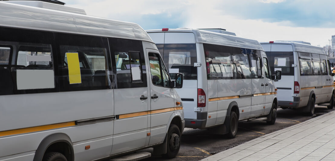 Drei Shuttle Busse stehen in einer Reihe am Flughafen