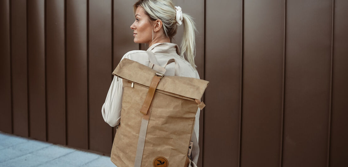 Eine Frau trägt einen Rucksack aus Papier