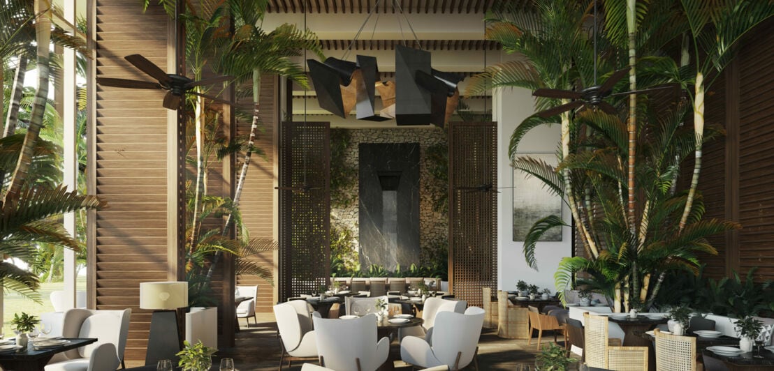 Ein modernes Hotelrestaurant mit warmen Designermöbeln und Palmen