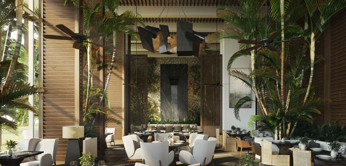 Ein modernes Hotelrestaurant mit warmen Designermöbeln und Palmen