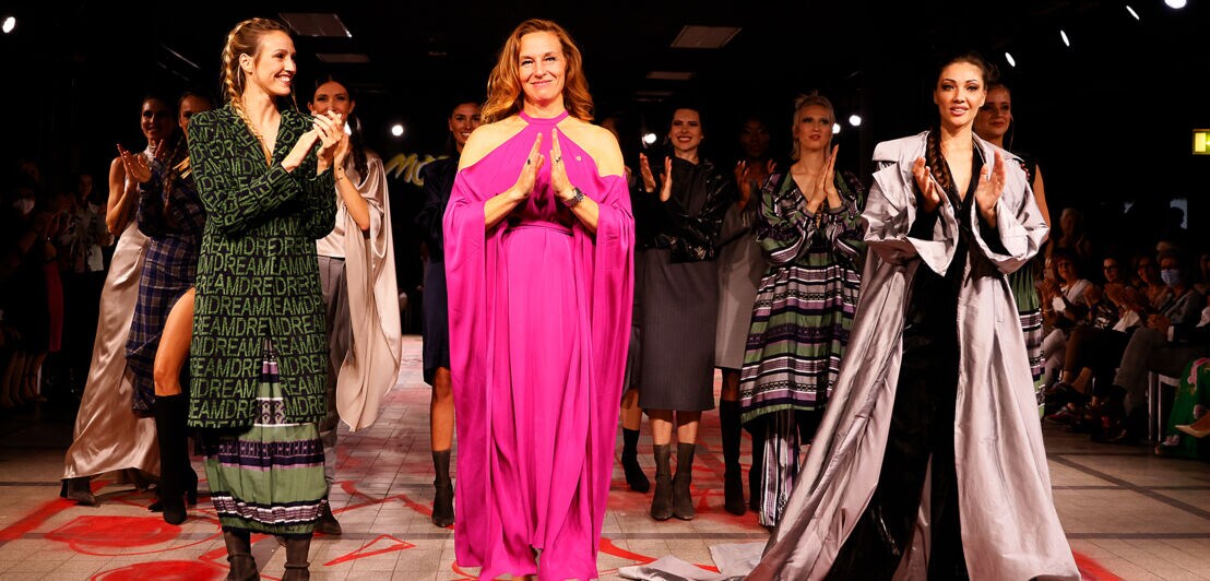 Anja Gockel im pinken Kleid auf dem Catwalk zusammen mit weiteren Models