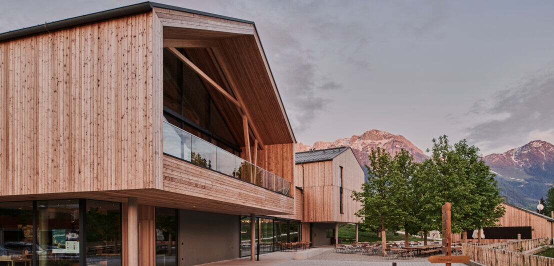 Ein moderner Hotelkomplex aus Holz vor Bergkulisse
