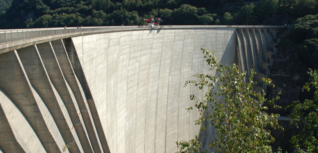 Ein Staudamm, auf dem Menschen stehen, die einen Bungeesprung absolvieren wollen