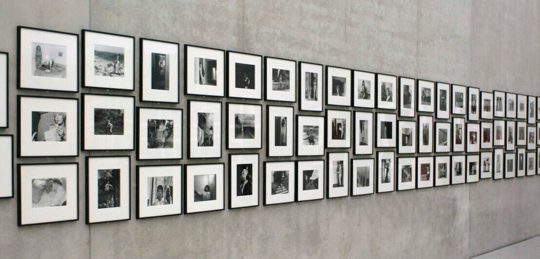 Gerahmte Schwarzweißfotos von Cindy Sherman hängen in einer Ausstellung an einer Betonwand