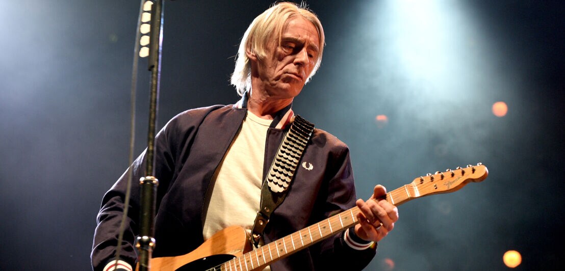 Nahaufnahme von Musiker Paul Weller mit einer Gitarre auf einer Bühne