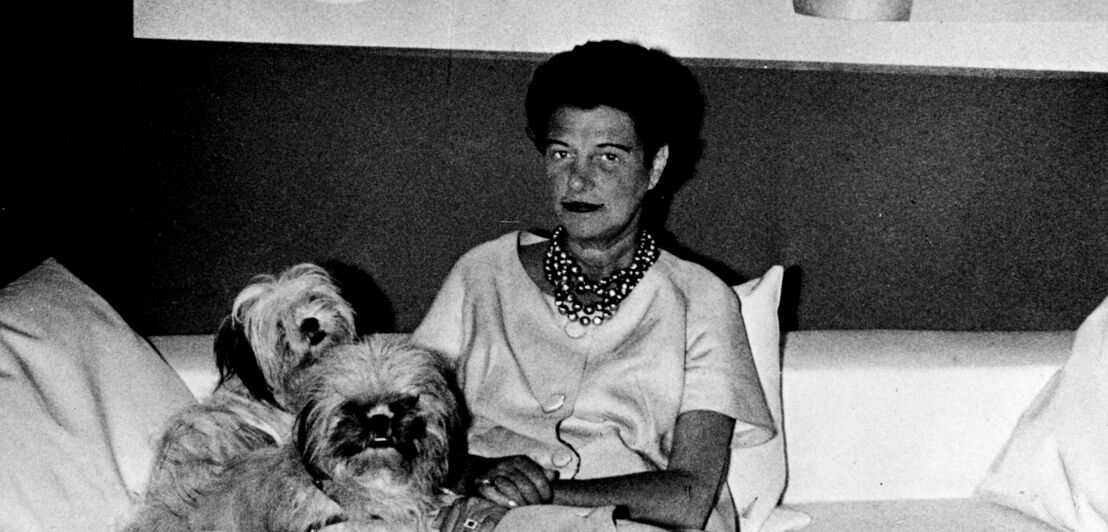 Porträt von Peggy Guggenheim auf einem Sofa mit zwei Hunden, Schwarzweißaufnahme