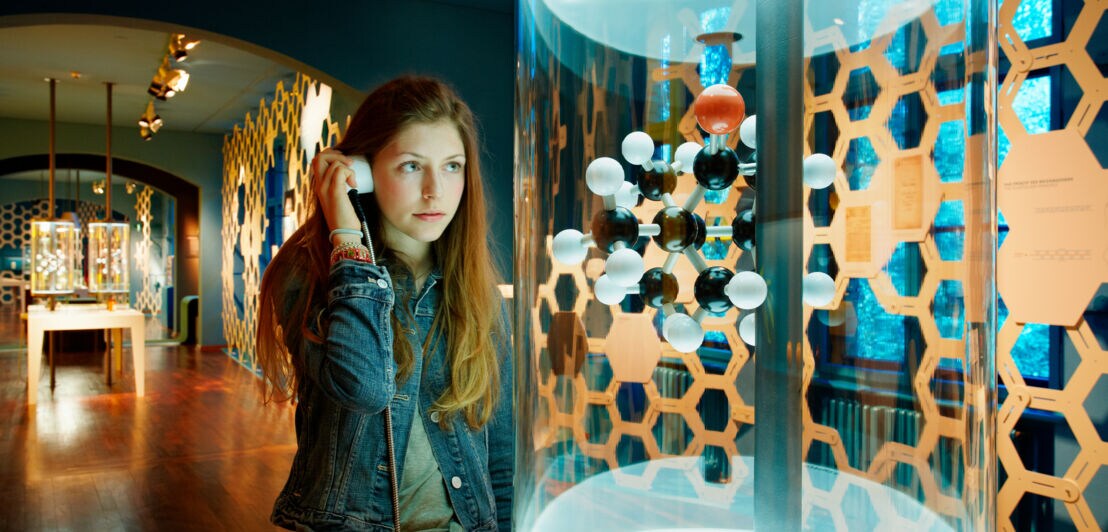 Ein Teenager am Modell eines Moleküls