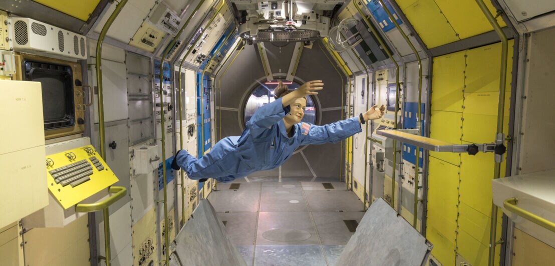 Ein Puppe schwebt im Spacelab.
