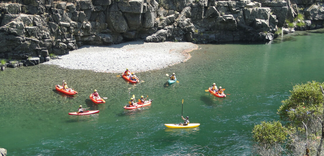 Eine Personengruppe bei einer Kajaktour auf einem Fluss 