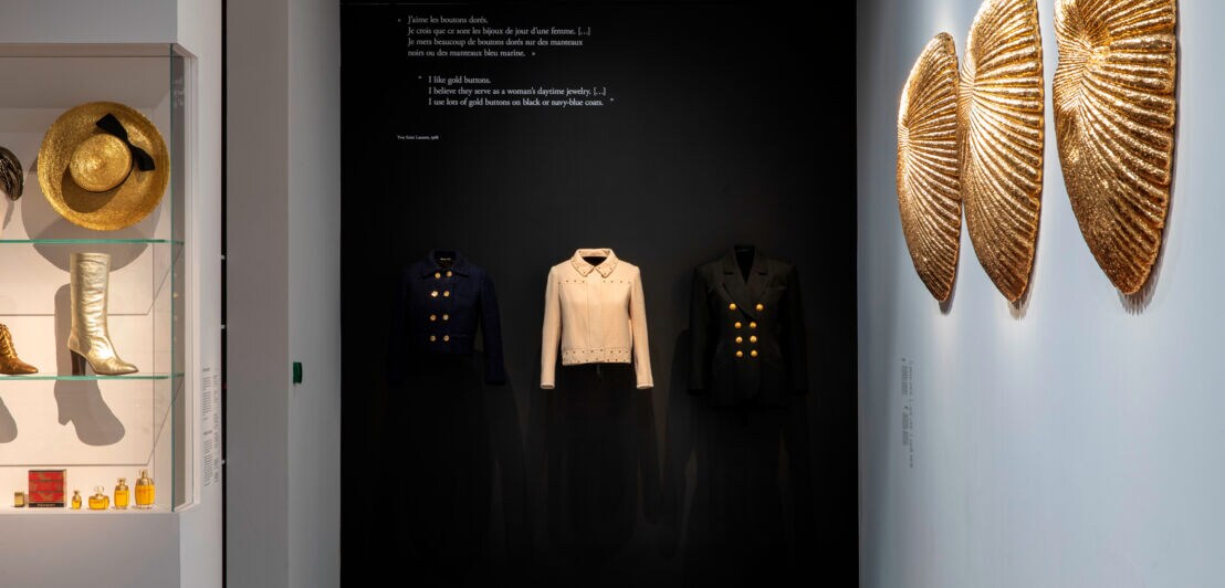 Ausstellungsstücke wie Oberteile, Hüte und Stiefel in Gold aus der Ausstellung GOLD im Museum YSL in Paris