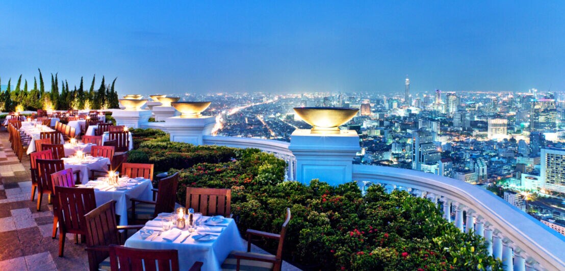Restaurantterrasse bei Abendlicht und mit Blick über die SKyline von Bangkok