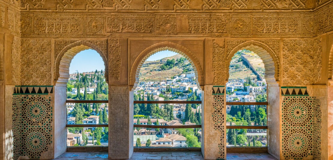 Drei Torbögen der Alhambra, im Hintergrund Granada und die Berge