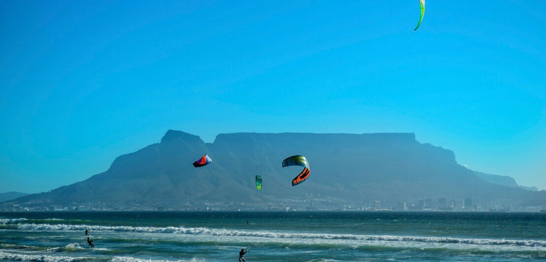 Kitesurfer im Meer, im Hintergrund Kapstadt am Fuße des Tafelbergs