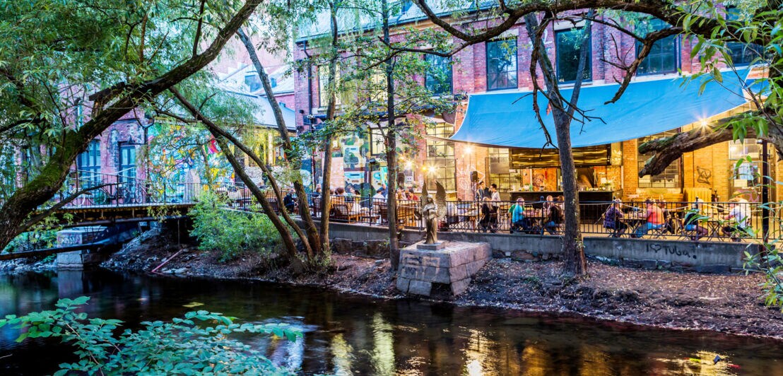 Belebtes Restaurant an einem Fluss in einer Stadt