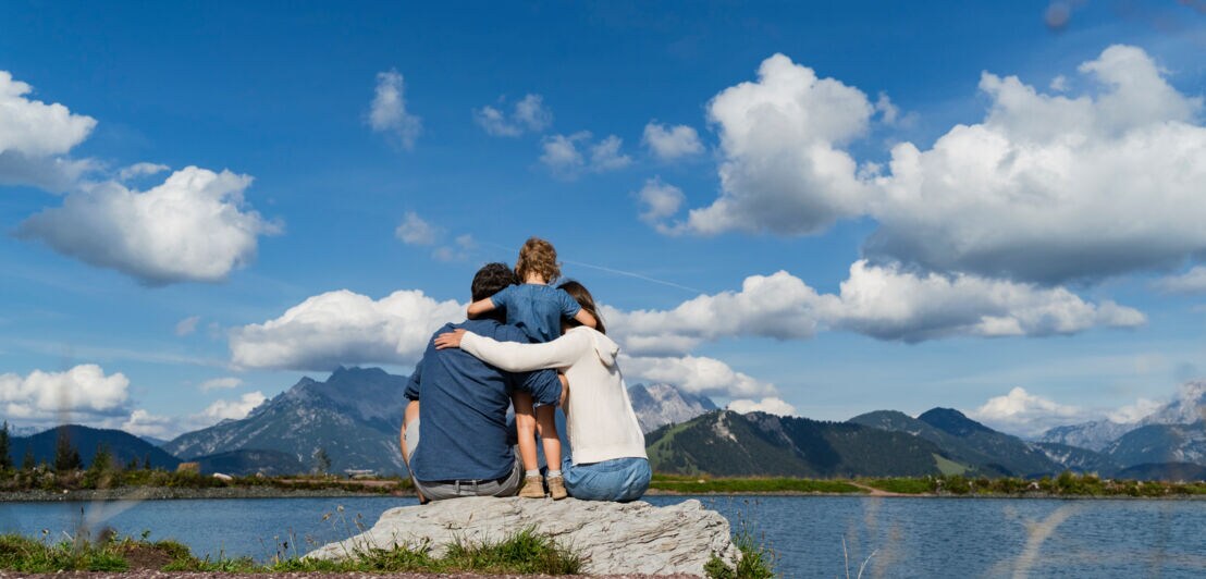 Eine Familie am Ufer eines Sees mit Bergpanorama
