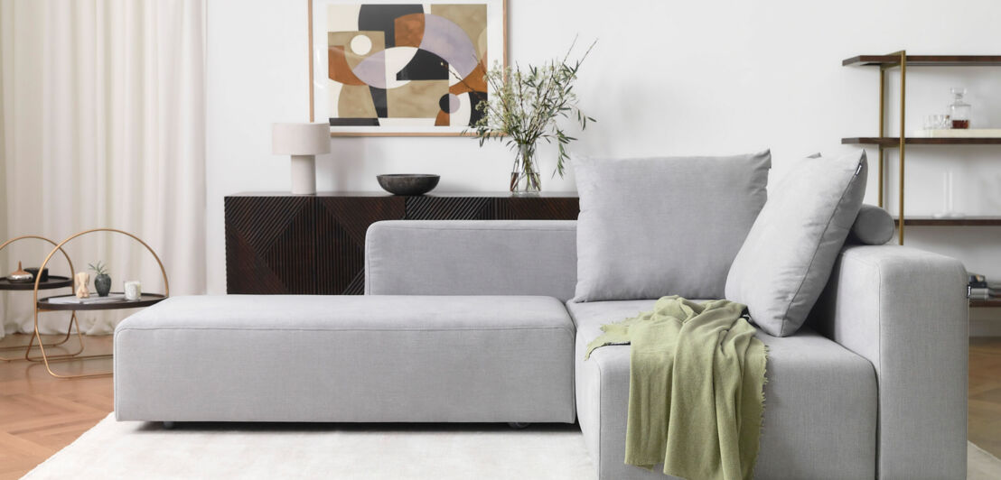 Ein graues Stoffsofa im kubistischen Design in einem modernen Wohnzimmer