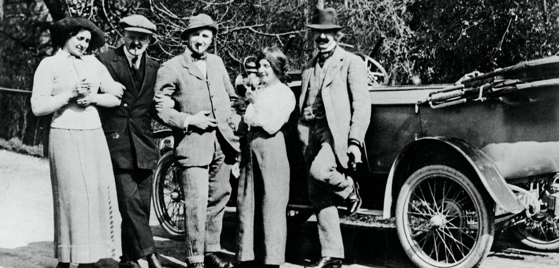 Historische Gruppenaufnahme vor einem Automobil