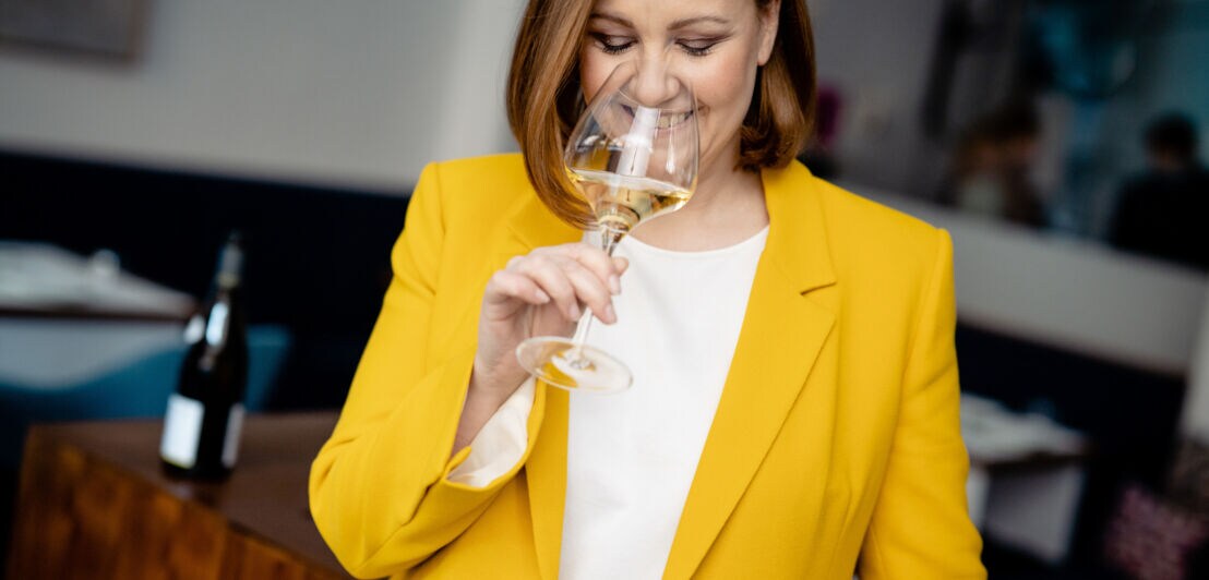 Marie-Anne Wild probiert einen Weißwein in einem Restaurant