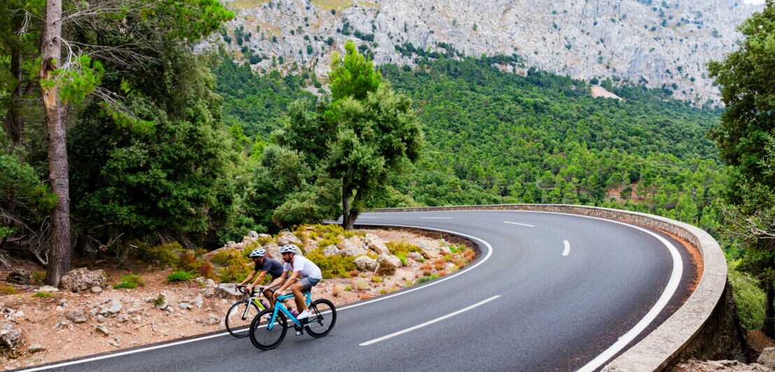 Zwei Menschen auf Rennrädern auf einer Straße in den Bergen von Mallorca