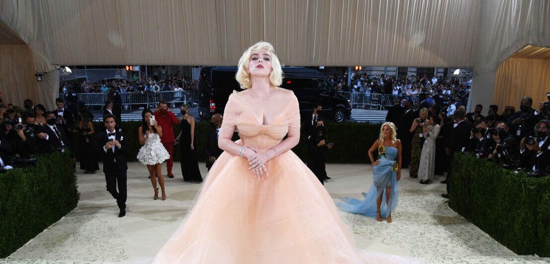 Billie Eilish posiert in hellem Abendkleid auf der Met Gala vor Fotografen