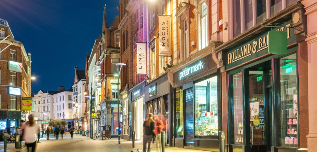 Beleuchtete Geschäfte und Pubs in der Grafton Street in der Innenstadt von Dublin