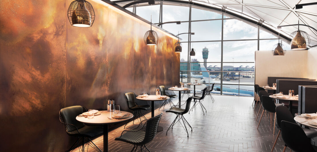 Modernes Restaurant in einer Flughafenlounge von American Express mit Panoramafenster mit Blick aufs Rollfeld