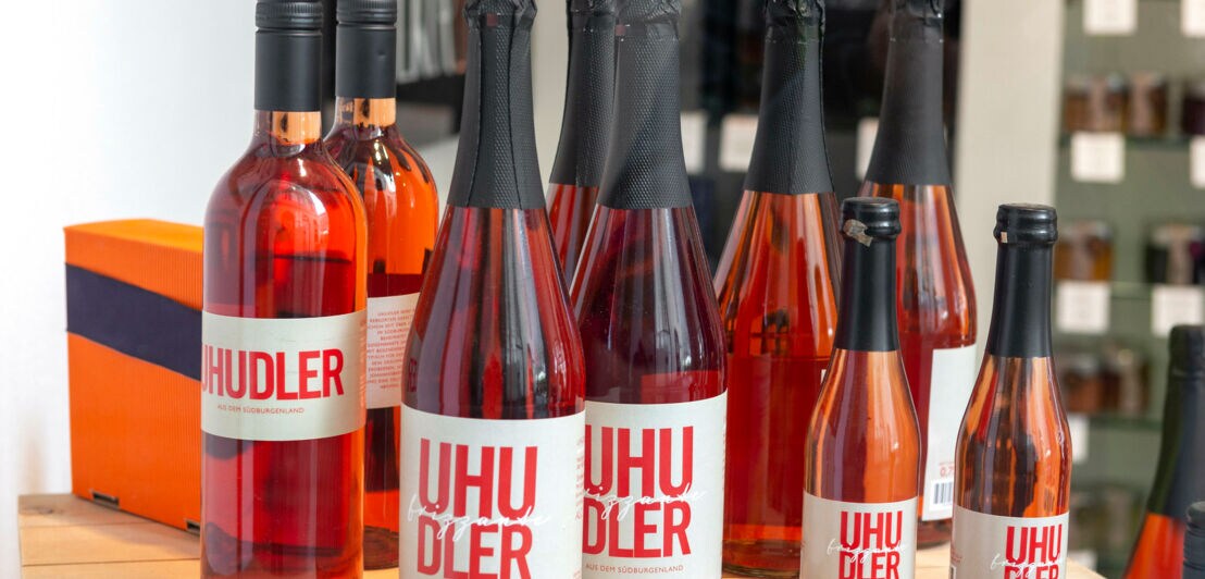 Arrangement von Weinflaschen mit Rosé in verschiedenen Größen der Marke Uhudlur auf einem Tisch