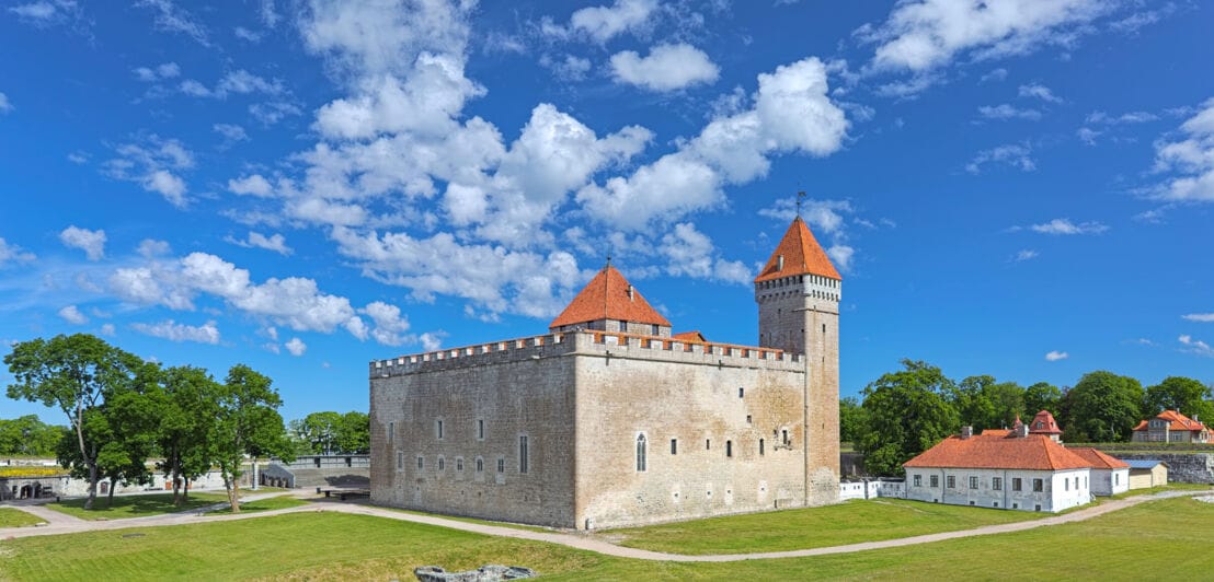 Aufnahme einer Burg vor blauem Himmel mit einigen wenigen Wolken.