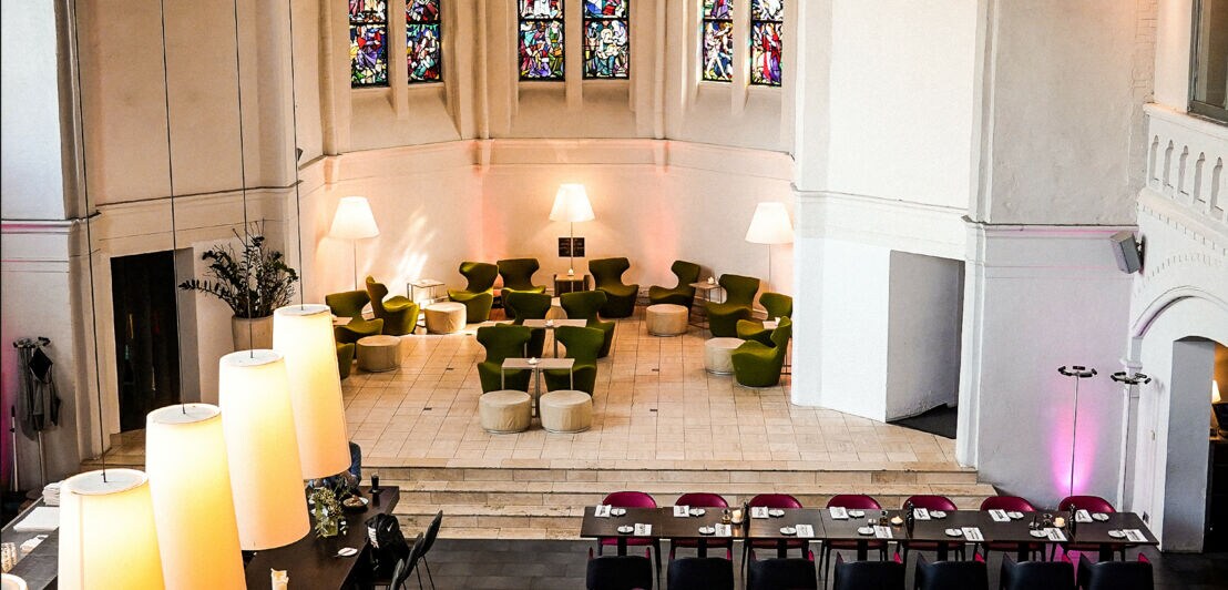 Blick auf Restauranttische und Stühle im Inneren einer Kirche