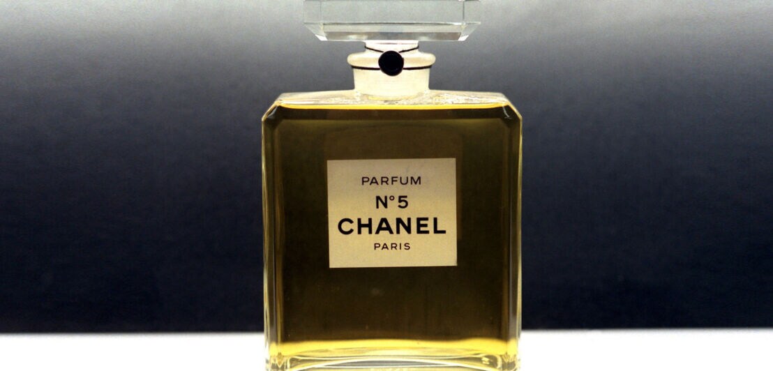 Produktaufnahme eines vollen Parfümflakons Chanel Nummer 5 vor grauem Hintergrund
