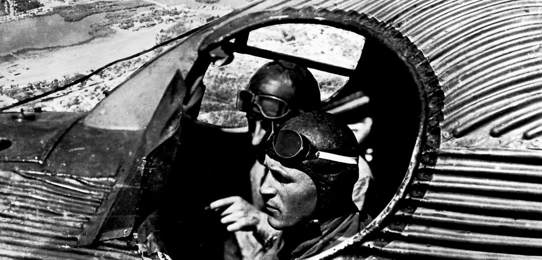 Altes Schwarzweißfoto von zwei Piloten in einem Flugzeug des Modelltyps Junkers