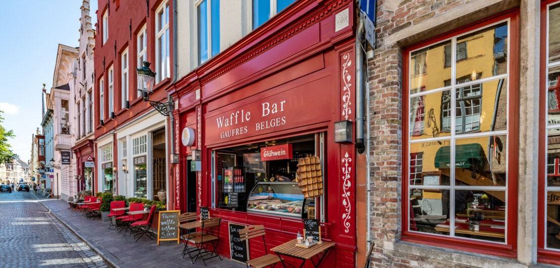 Blick auf Cafés mit historischen Fassaden an Bürgersteig