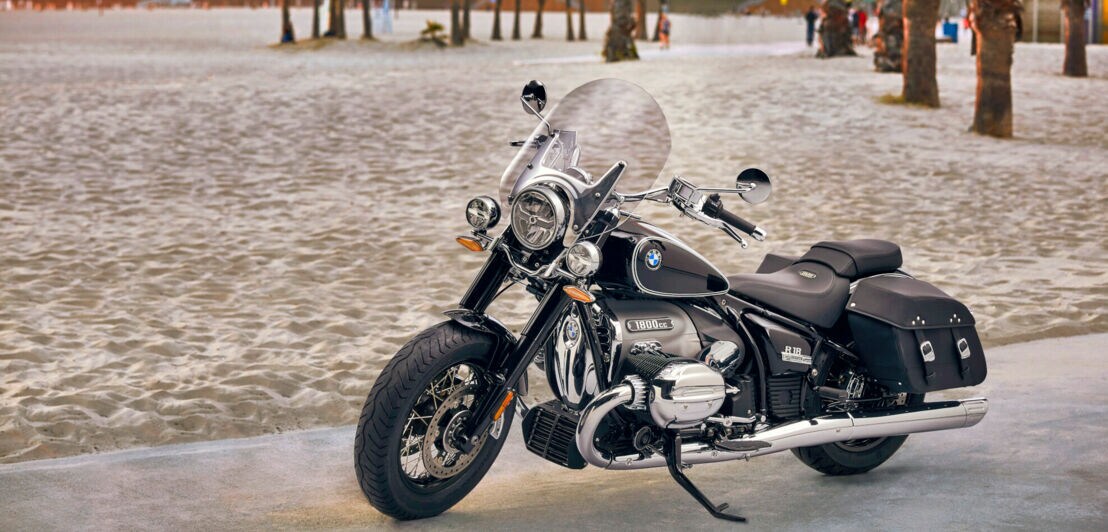 Ein BMW-Motorrad R 18 im schwarzen Retrodesign mit Chromdetails am Strand