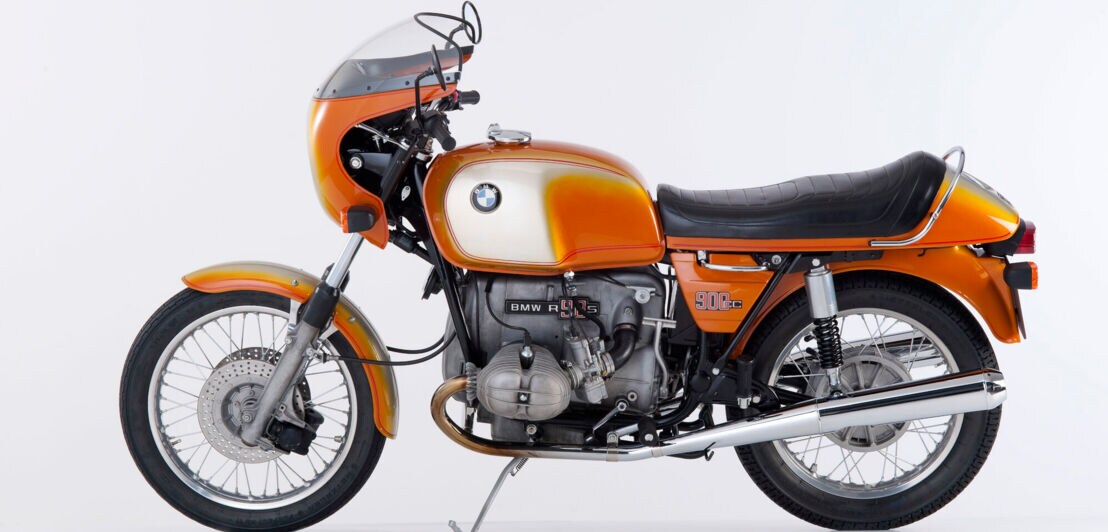 Produktfoto eines BMW-Motorrad R 90 S in orangefarbenem Design vor weißem Hintergrund