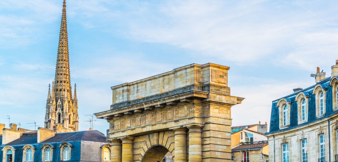 Stadtpanorama der historischen Altstadt von Bordeaux mit Torbogen und Kirchturmspitze